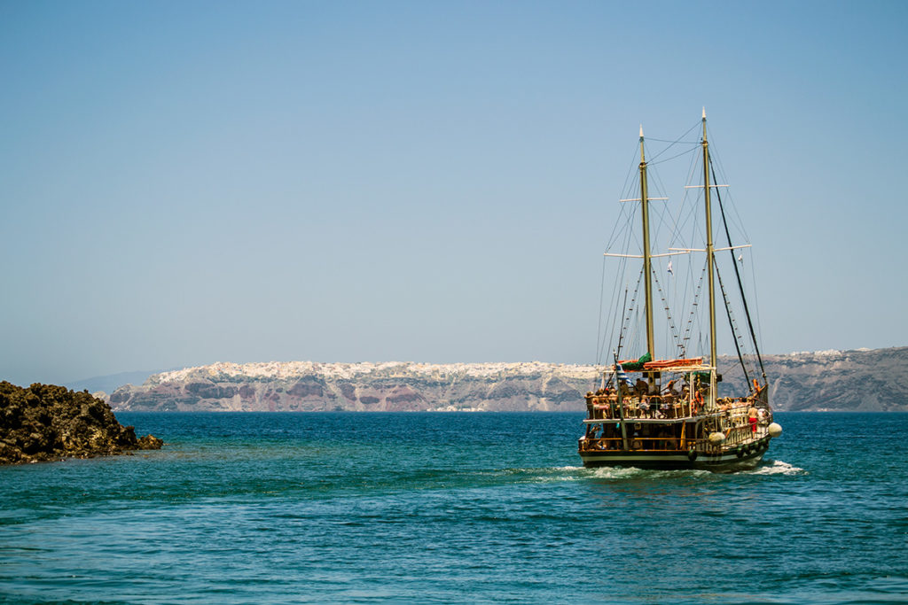 Barco y vistas del pueblo de Oia - Descubrir Santorini