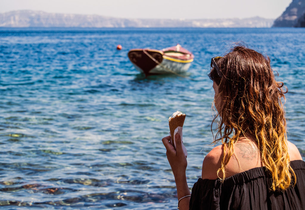 Nerea tomando un helado en la playa pedregosa de Therasia - Descubrir Santorini