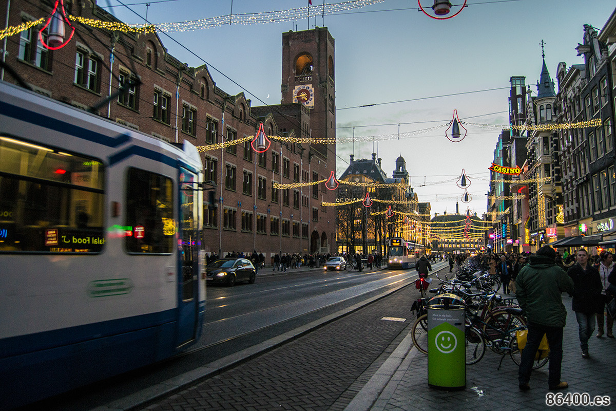 Calle Damrak iluminada con luces navideñas - Disfrutar Amsterdam